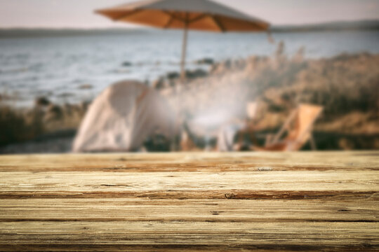Wooden table with copy space and blurred summer barbecue background