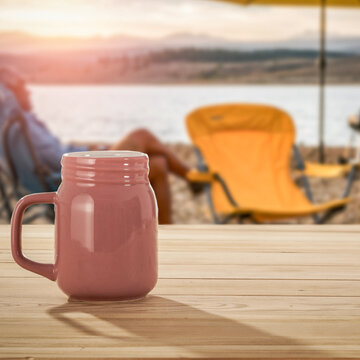 Lake camping with mountain view and wooden table with copy space &ndash; outdoor summer adventure concept.