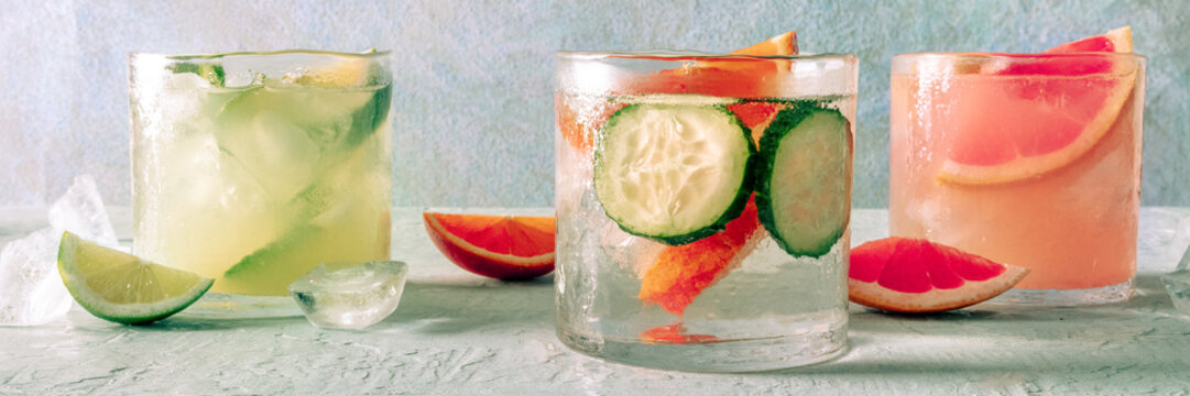 Refreshing summer cocktails with ice cubes on a light background