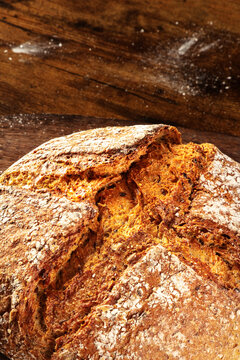 Homemade artisan sourdough bread loaf on a rustic wooden cutting board