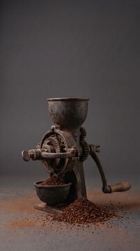 Vintage manual coffee grinder with fresh ground coffee on dark background, rustic coffee mill mockup