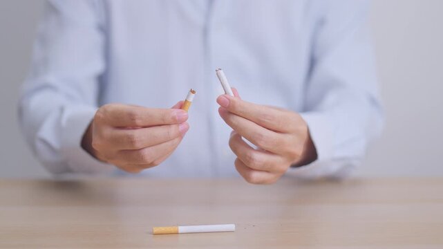 Man hand break cigarette for World No Tobacco Day concept, quitting smoking to prevent Lung Cancer, COPD, Emphysema and Tuberculosis disease. healthy lifestyle resolution, stop nicotine addiction