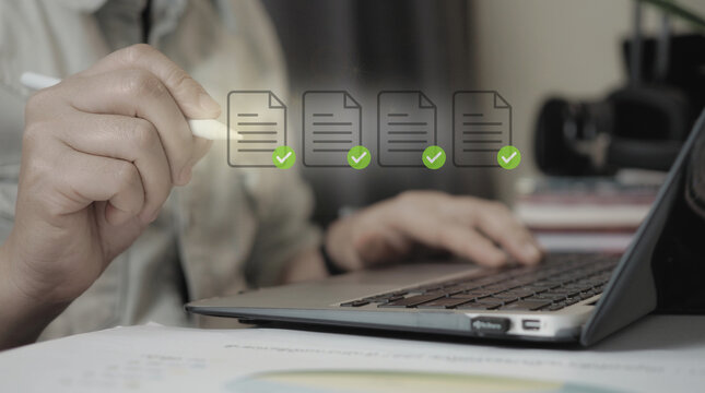 Businessman reviewing and approving digital documents with checkmark icons on laptop, paperless office concept