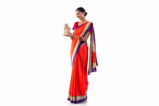 Portrait of a young woman putting coin into money box