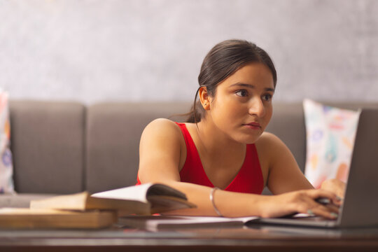Portrait of a teenage girl doing homework during online classes