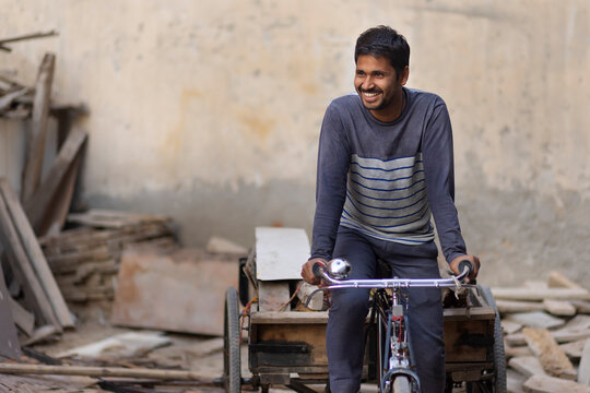 A Rickshaw puller taking away scrap