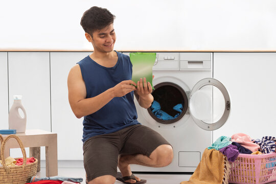 Portrait of young man doing laundry