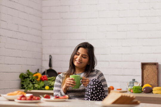 Portrait woman drinking coffee during breakfast in kitchen