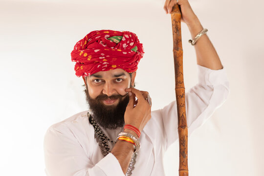 Close-up portrait of Rajasthani young man standing against white background