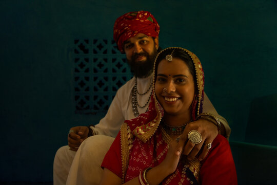 Portrait of happy Rajasthani couple sitting together on stairs