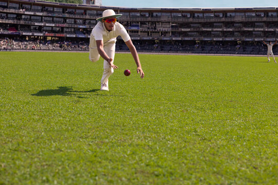 A fielder about to catch the  ball during a cricket match