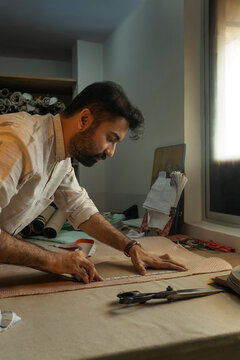 Fashion designer tracing patterns on the cloth 