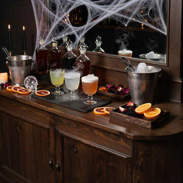 halloween themed bar with cocktails, spider web decorations, and mood lighting in dark ambiance