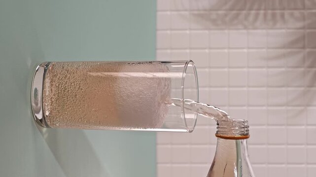 Pouring lemonade into a glass while bubbles and gases form on the surface
