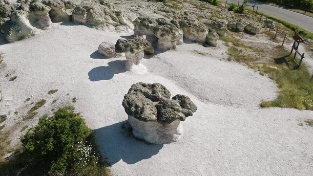 Stone Mushrooms Beli Plast volcanic tuff rock formations standing on white ground Kardzhali Bulgaria aerial drone shot bright summer day unique geological landmark nature travel background