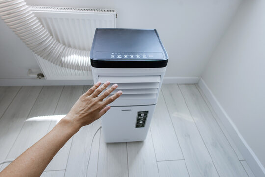 High-angle view of unrecognizable person checking chilly airflow with hand from mobile monoblock air conditioner