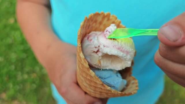 Enjoying a colorful ice cream cone in a sunny park during the summer