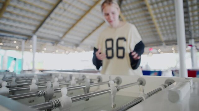 Family Enjoys Foosball At A Game Center As A Girl Confidently Scores, Updates The Scoreboard