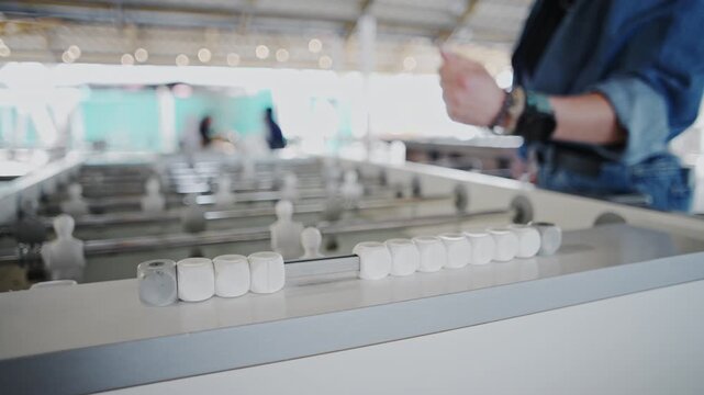 Girls Play Foosball In An Entertainment Center A Hand Shifts The Score Bead After A Goal