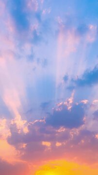 A vertical time-lapse shot reveals stunning sunbeams piercing through storm clouds during the golden hour, creating a spectacular sky filled with natural rays, with ample negative space for text.