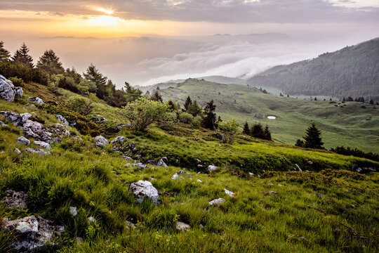 Scenic mountain hiking trail from Altissimo refuge to Malga Campo, overlooking mist at sunset Monte Baldo Natural Park, Brentonico, Trentino, Veneto, Italy.
