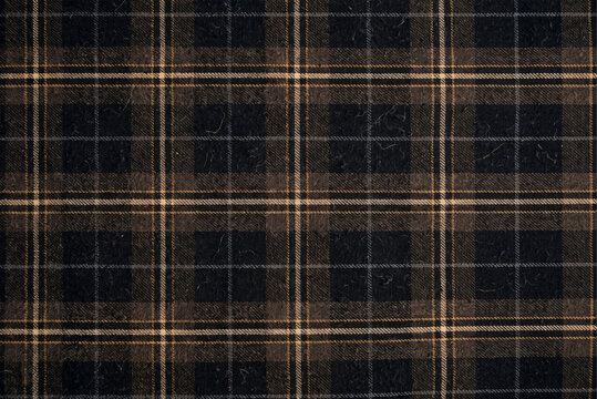 Vintage Black and Brown Tartan Fabric Pattern in a Worn Textile Close-Up