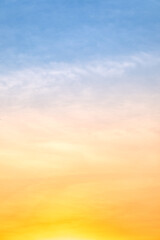 Sunset or sunrise sky with a vibrant gradient of orange, gold, and soft blue. Clear atmosphere with wispy clouds. Peaceful, natural light background. hope, freedom, new day Concepts, Vertical © ISENGARD