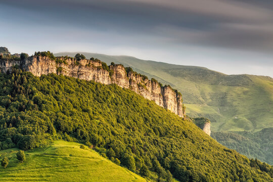 Rocky mountain cliffs and lush forest slopes form a scenic outdoor tourism destination in Monte Baldo Natural Park, Brentonico, Trentino, Veneto, Italy.