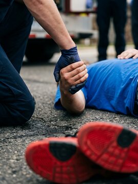 Paramedic Helping Unconscious Person Lying on Ground.