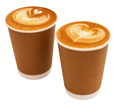 Coffee. Two disposable coffee cups featuring intricate latte art designs on surface, with brown paper exterior and white plastic bottoms, positioned side by side. Isolated