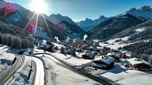Drone view of snowy mountain village under bright sun