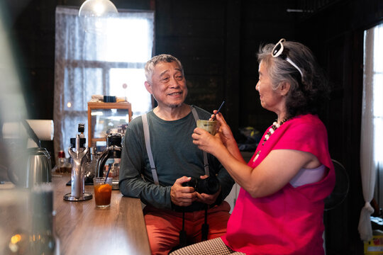 Seniors enjoy conversation at a coffee shop in the afternoon with drinks and a camera on the counter