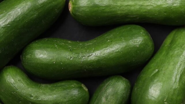 Fresh whole mini Dutch cucumbers slowly rotating. Top view shot
