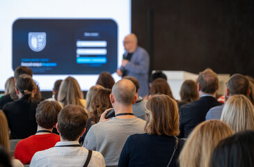 Fototapeta premium Business audience seated and focused on presenter, corporate seminar with networking and learning atmosphere.