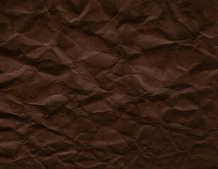 Fototapeta premium Dark brown crumpled paper texture with pronounced folds and matte finish. High resolution abstract background for graphic design, branding and creative projects.