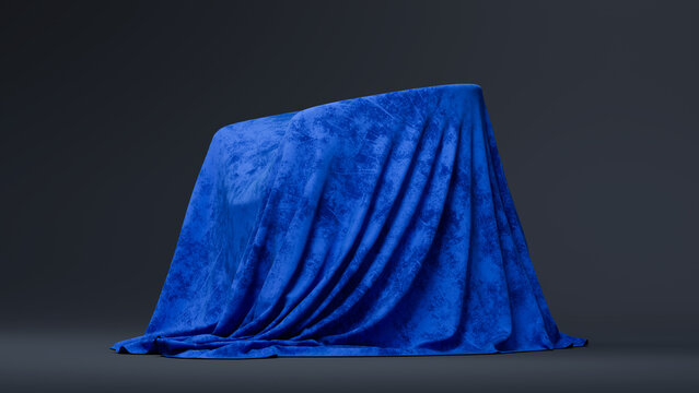 A blue fabric with a mottled texture object rests on a dark gray surface against a matching gradient background. Copy space. 