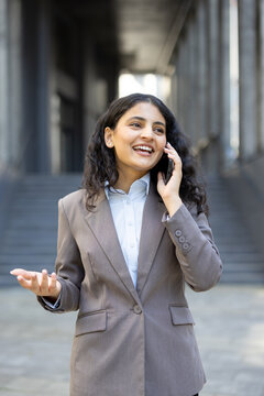 Professional woman confidently communicating on mobile phone outside office