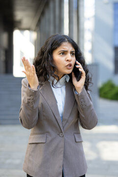 Frustrated businesswoman communicating on smartphone having an argument