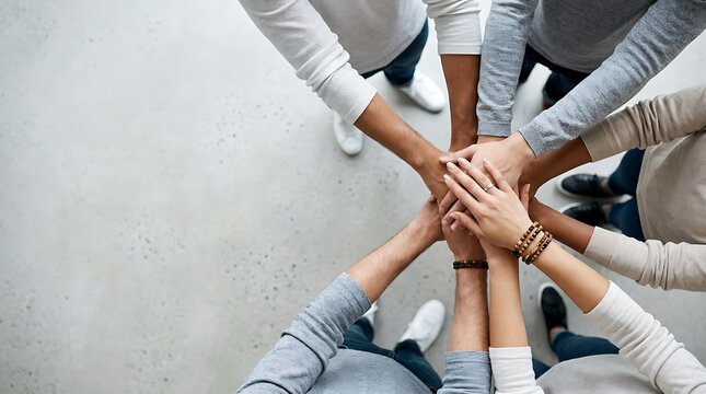 Teamwork and unity shown by people joining hands in circle, close up, demonstrating collaboration and support, top view, modern office background.