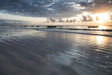 Biała piaszczysta plaża na Zanzibarze w promieniach wschodzącego słońca © kubikactive