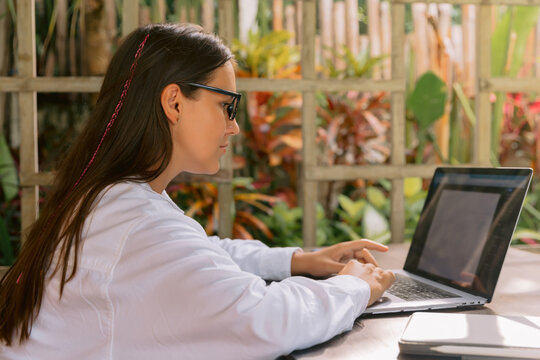 Wwoman working on laptop outdoors with natural background