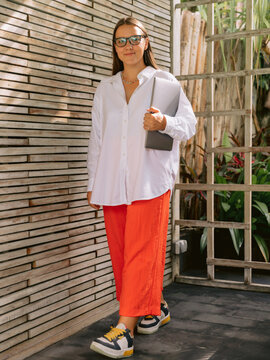 Woman in casual outfit standing outdoor near contemporary architecture