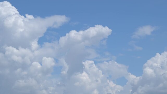 beautiful time lapse video of soft cumulus clouds moving across the bright blue sky in sunny weather