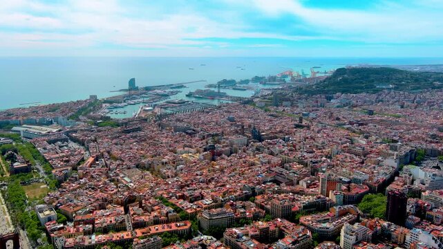 Aerial view of Barcelona, Spain, with the Gothic Quarter, cathedral spires, Arc de Triomf, Port Vell marina, cruise ships at the harbor terminals and Montjuic hill by the Mediterranean.