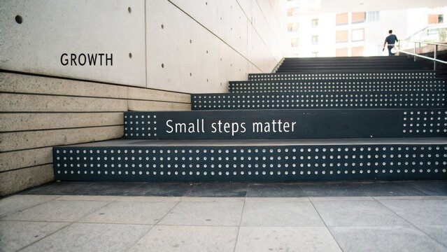Inspirational Growth Message on Steps Emphasizing Small Steps Matter in Urban Environment with Modern Architecture Elements