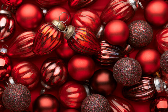 Close up of pile red Christmas ornaments, various size, shades and textures. Christmas Holiday background.  Flat lay