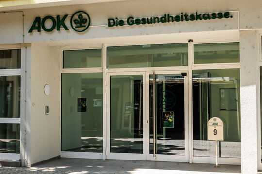 Neuwied, Germany - July 13, 2026: AOK Die Gesundheitskasse building exterior showing its main entrance with glass doors, prominent green logo and company name, reflecting its health insurance role