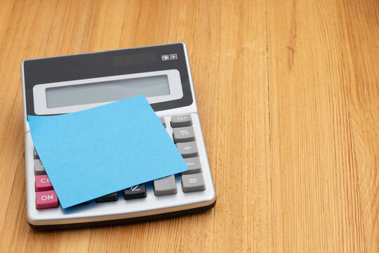 Budget planning concept with calculator and sticky note