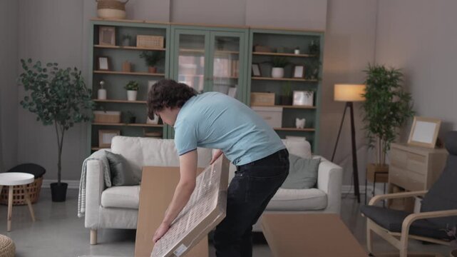 Young man assembling new furniture in living room