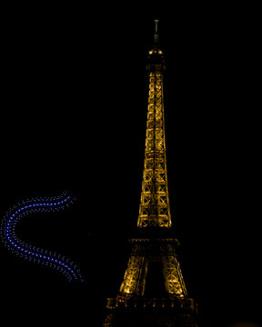 The golden illuminated Eiffel Tower stands against the night sky in Paris France on July 13 2026